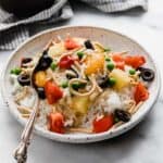 Loaded Slow cooker Hawaiian haystacks with the best Hawaiian haystacks toppings on a white plate on a white background.