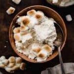Toasted Marshmallow Frosting made with real toasted marshmallows, in a brown bowl on a dark brown surface.