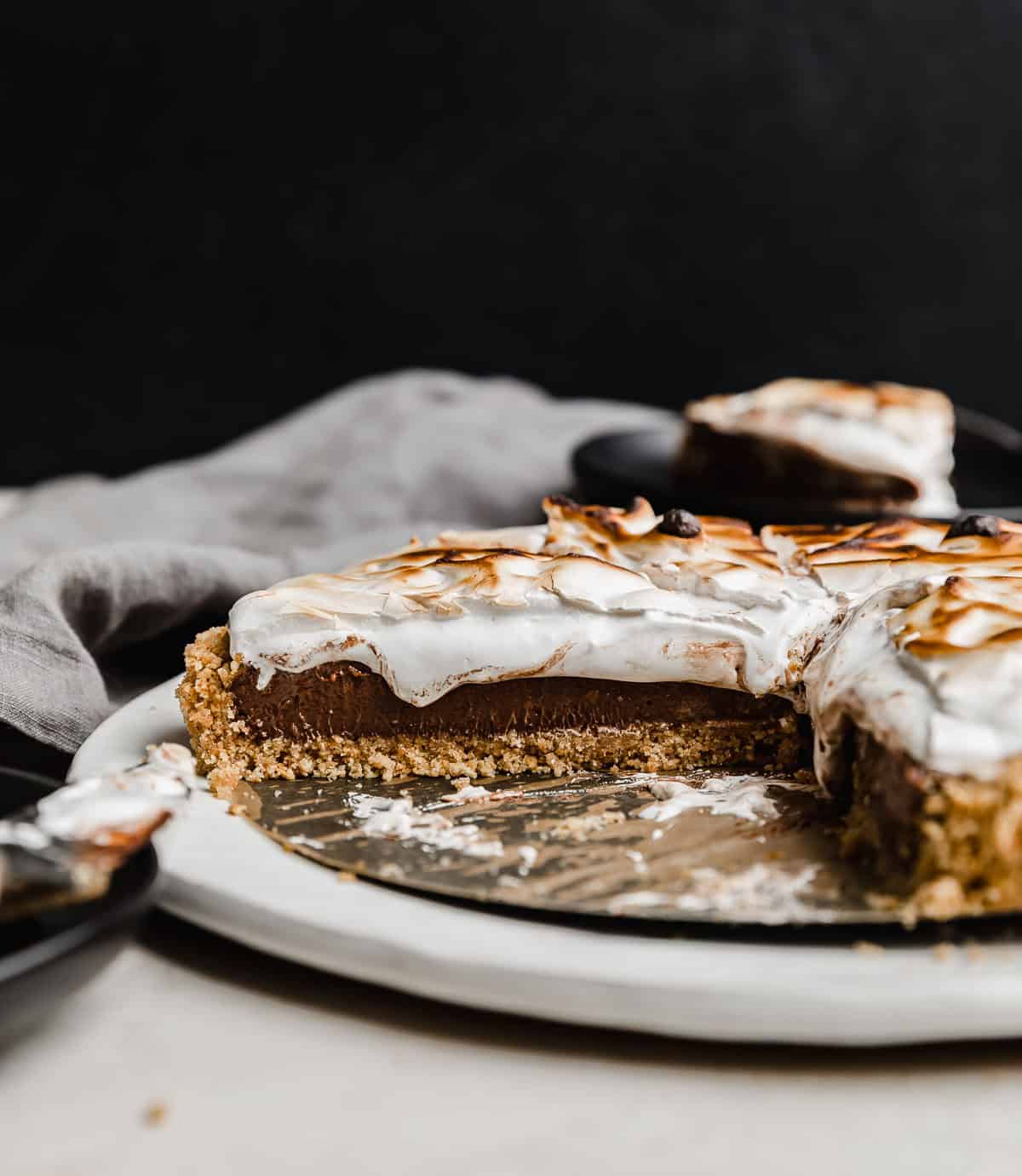 A S'mores Pie recipe made with graham cracker crust, chocolate pudding, and marshmallow cream, against a black background.