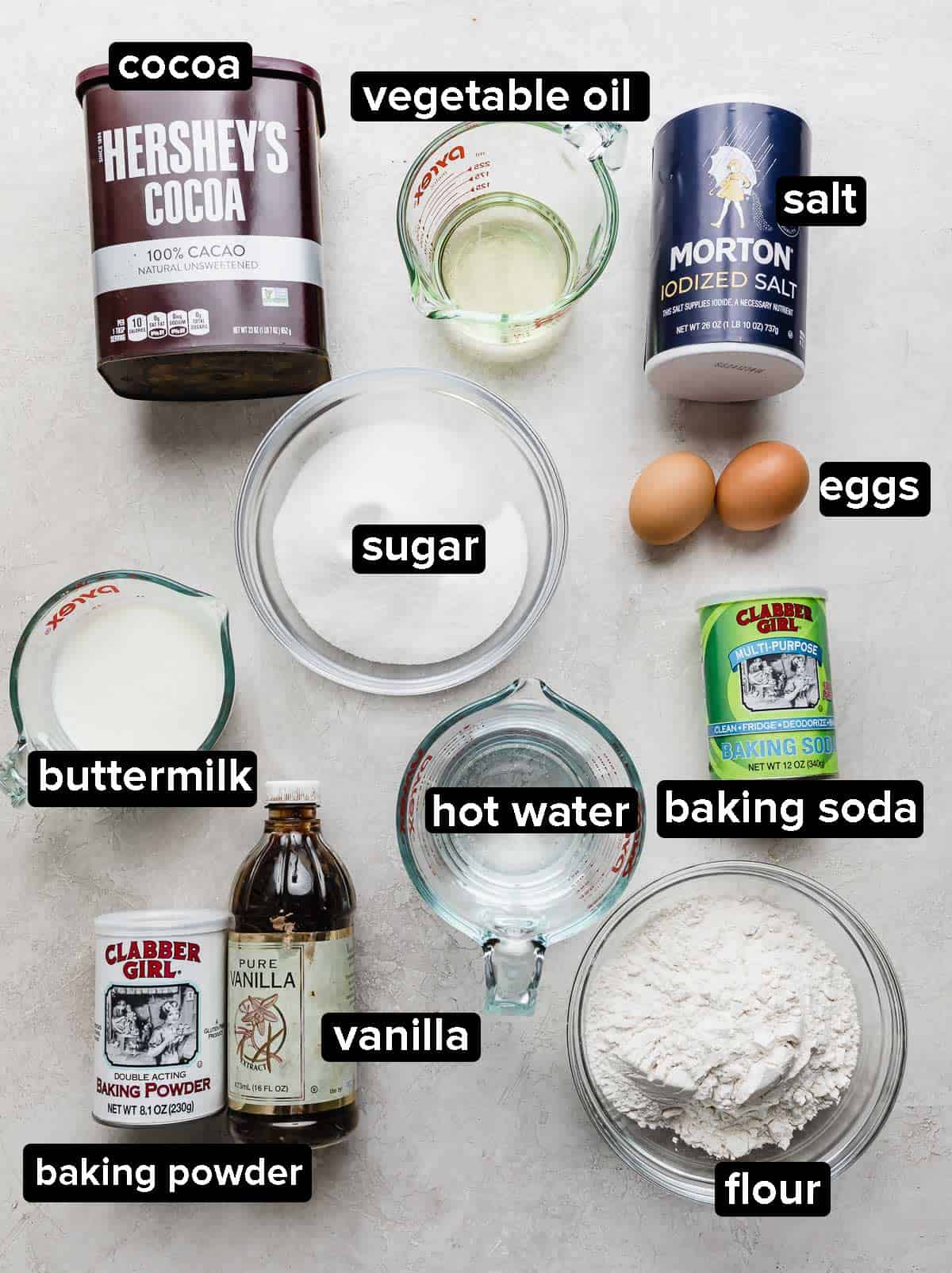 Chocolate Poke Cake ingredients portioned into glass bowls on a white background.