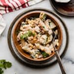 Creamy Mexican Street Corn Pasta Salad recipe in a brown bowl on a white marble surface.