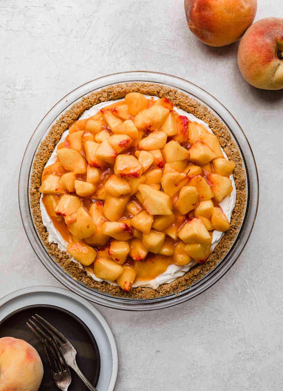 Overhead photo of the best fresh peach pie made with cream and cream cheese, on a light gray background.