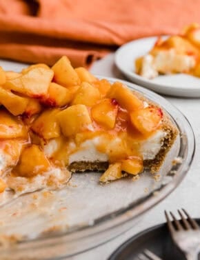 A Peach Cream Pie made with cream cheese base layer on a graham cracker crust and topped with chopped fresh peaches.