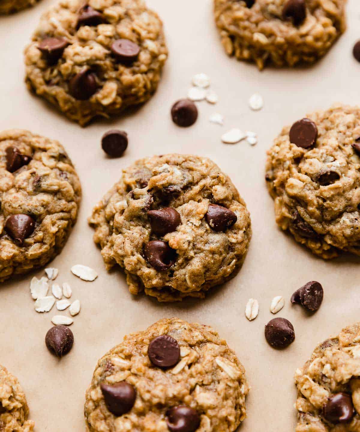 Chocolate Chip Oatmeal Pumpkin Cookies topped with semi-sweet morsels on a Kraft parchment paper.