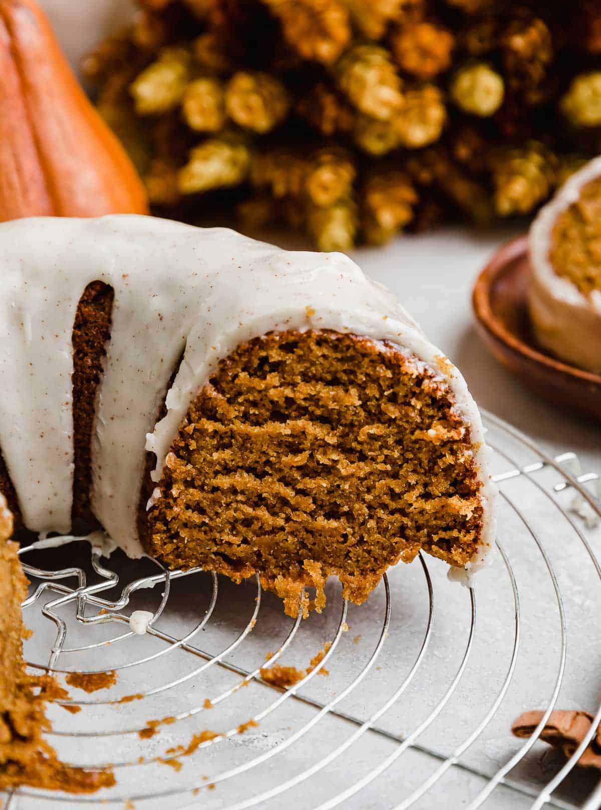 A slice of pumpkin bundt cake topped with brown butter glaze.