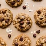 Oatmeal chocolate chip Pumpkin Cookies topped with semi-sweet morsels on a Kraft parchment paper.