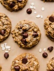 Oatmeal chocolate chip Pumpkin Cookies topped with semi-sweet morsels on a Kraft parchment paper.