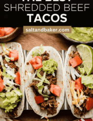 Crock Pot Shredded Beef Tacos on a brown plate with the words, "the best shredded beef tacos" written in white text above the photo.