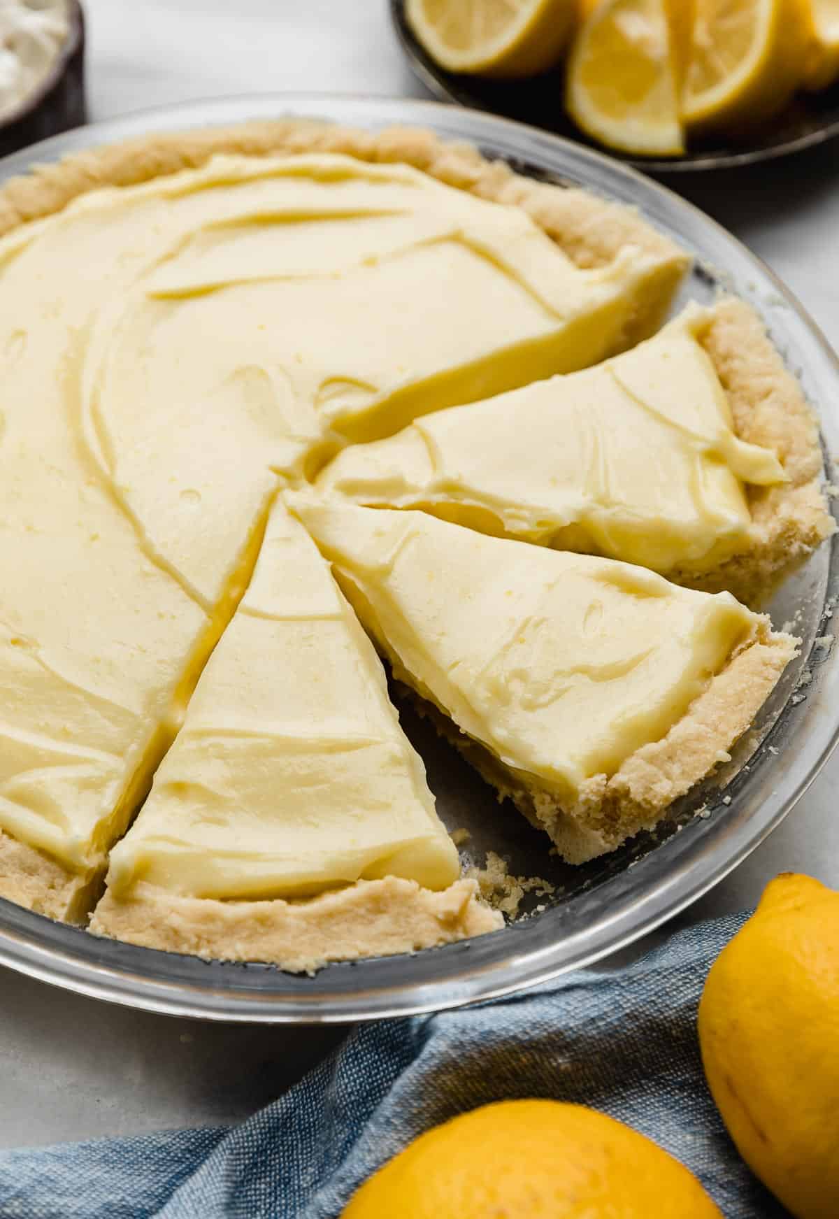 Lemon sour cream pie filling in a shortbread pie crust, with three pie slices cut.