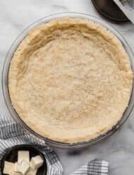 Shortbread Pie Crust baked in a 9" round pie plate on a light gray marbled surface.