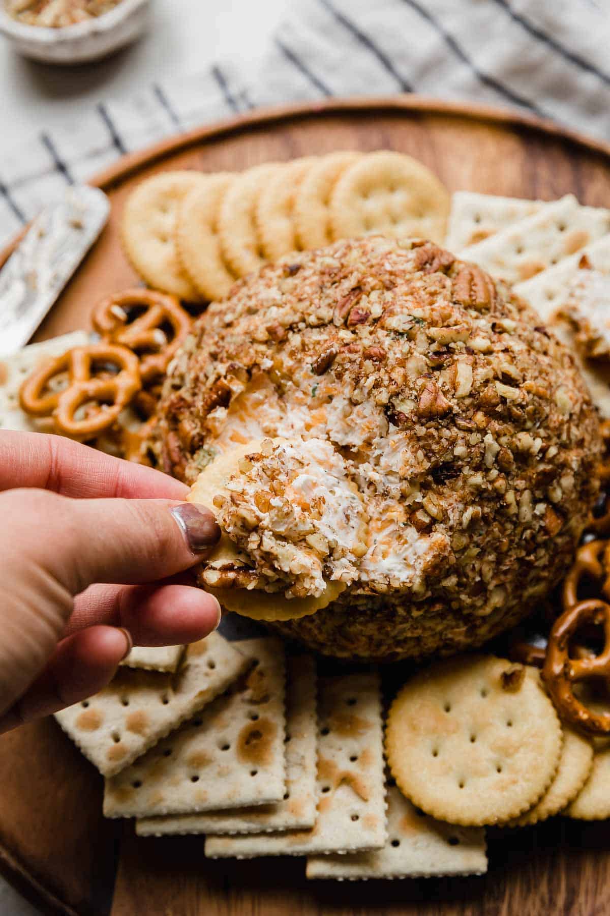 A cracker dipped into a Christmas Cheese Ball recipe.