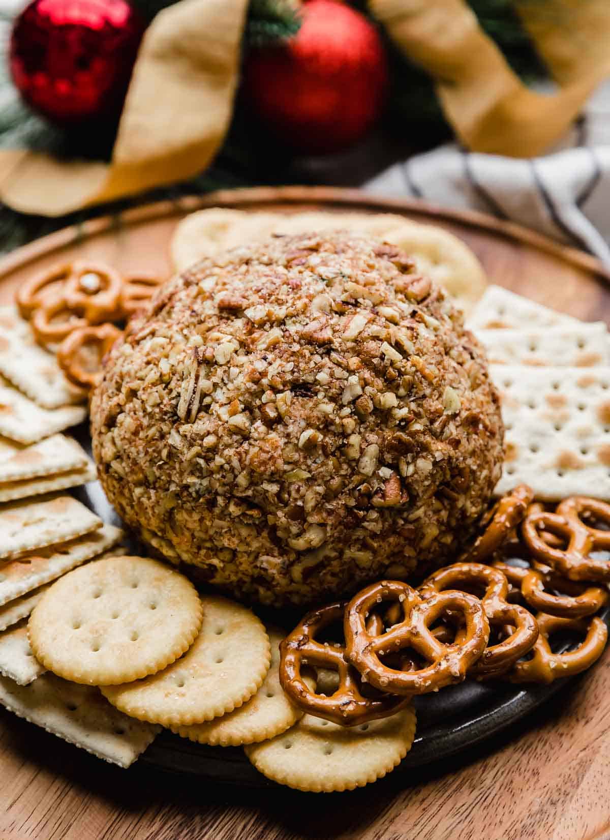 Pecan covered cheese ball with ranch seasoning on a brown plate.