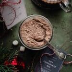 Overhead photo of homemade hot chocolate mix in a jar with a spoon in it.