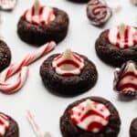 A chocolate cookie topped with a red and white striped Hershey's peppermint kiss.