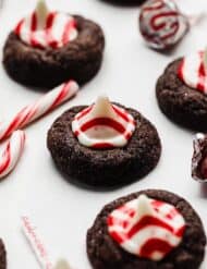 A chocolate cookie topped with a red and white striped Hershey's peppermint kiss.