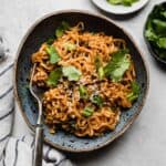 Creamy peanut butter Gochujang Ramen in a blue bowl on a gray background.