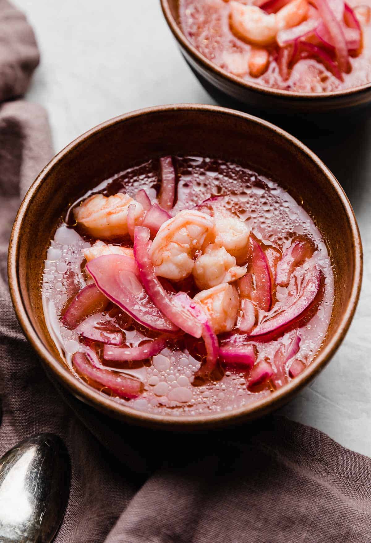 Shrimp Ceviche with purple onion in a lemon and lime juice mixture.