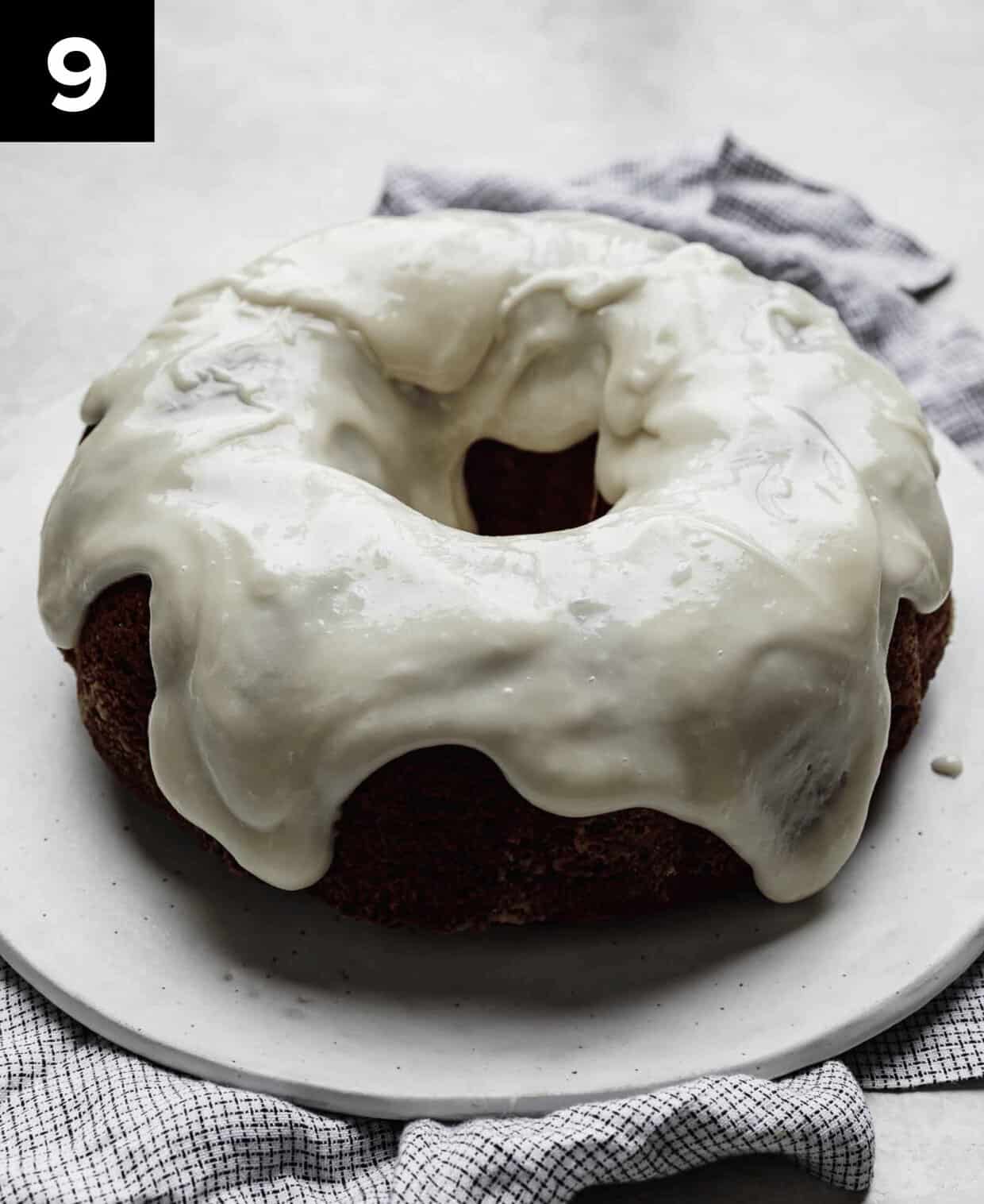 Cream cheese glazed Red Velvet Bundt Cake on a white plate.