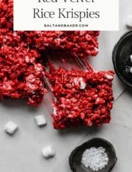 Red colored Rice Krispies treats on a light gray background with the words, "Red Velvet Rice Krispies" written in black text above the photo.