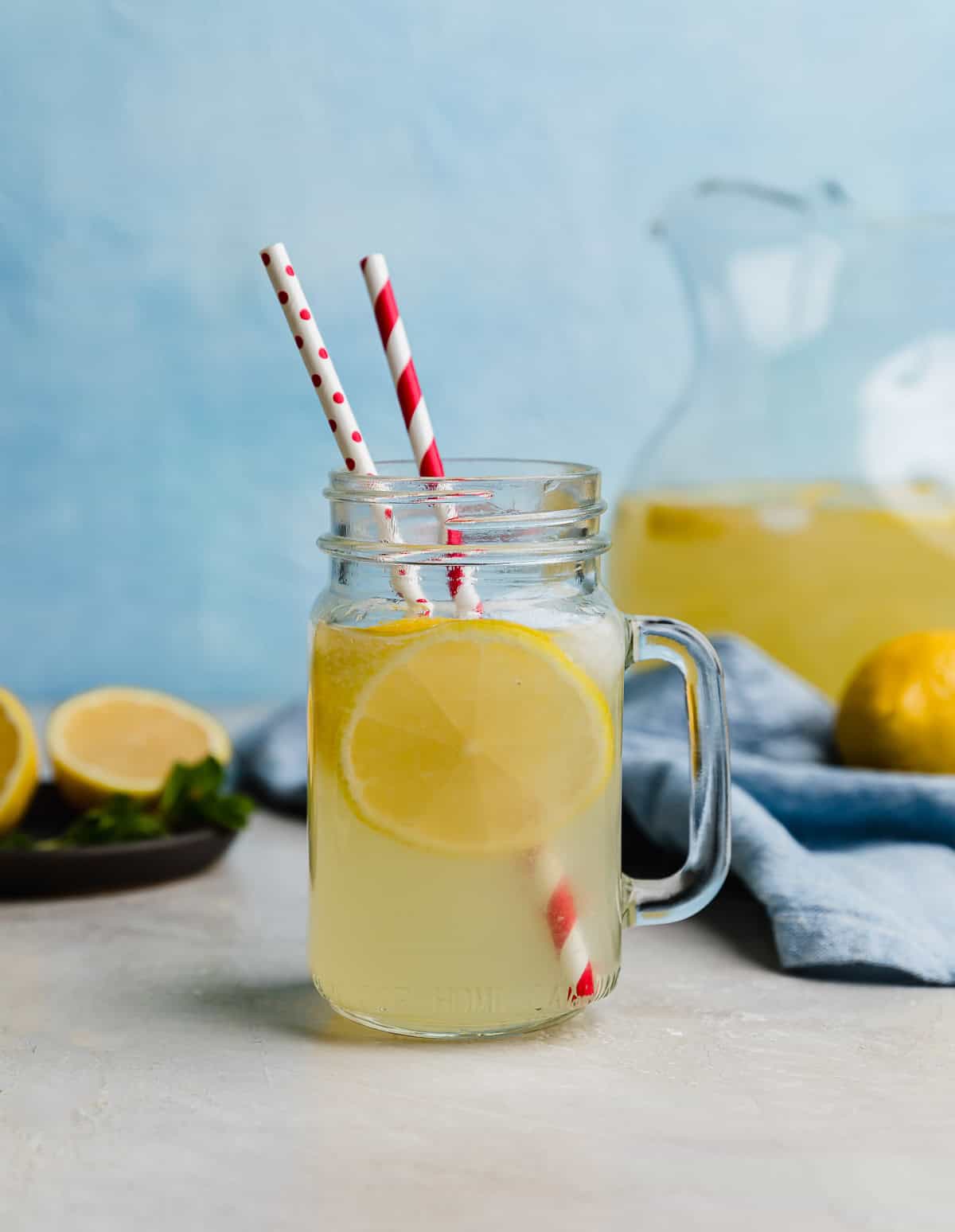 A mason jar cup filled with homemade Chick-fil-A Lemonade Recipe with two red straws in the cup.