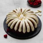 A Nothing Bundt Cake White Chocolate Raspberry Bundt Cake copycat recipe on a black plate on a light gray background.