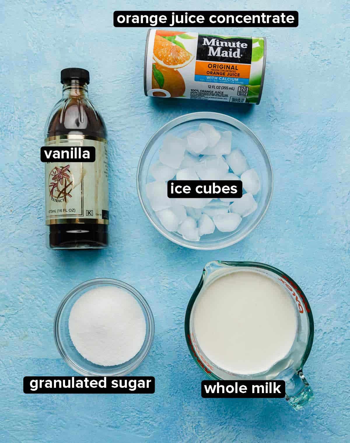 Orange Julius Recipe ingredients on a bright blue background: vanilla, orange juice concentrate, ice cubes, milk, and sugar.