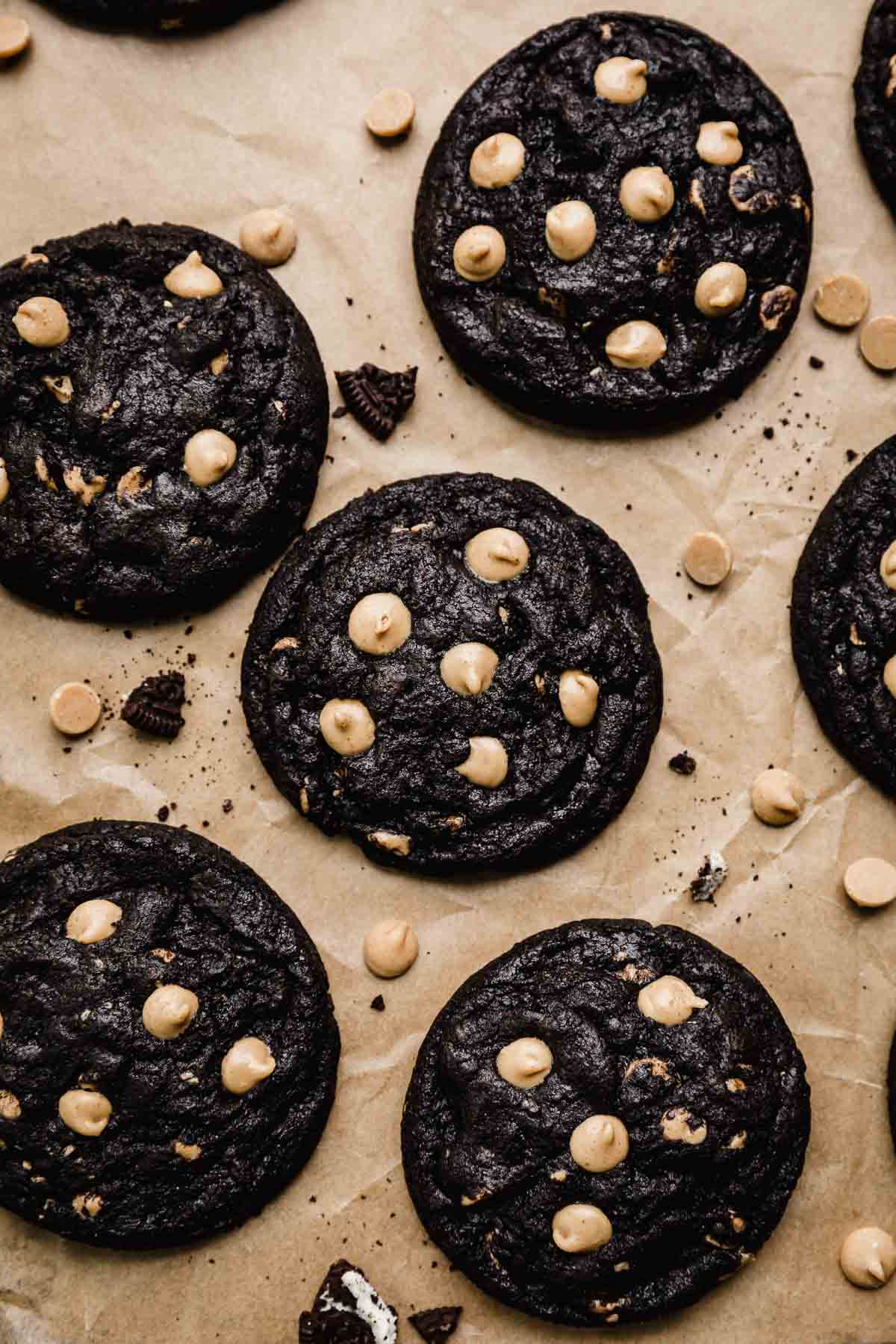 Baked Peanut Butter Oreo Cookies with a few peanut butter chips and Oreo pieces around the cookies.