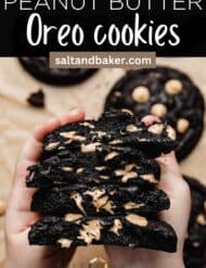 Oreo peanut butter cookies cut in half and held by two small hands showcasing the melty peanut butter chips with the words, "Peanut Butter Oreo Cookies" written in white text above the photo.