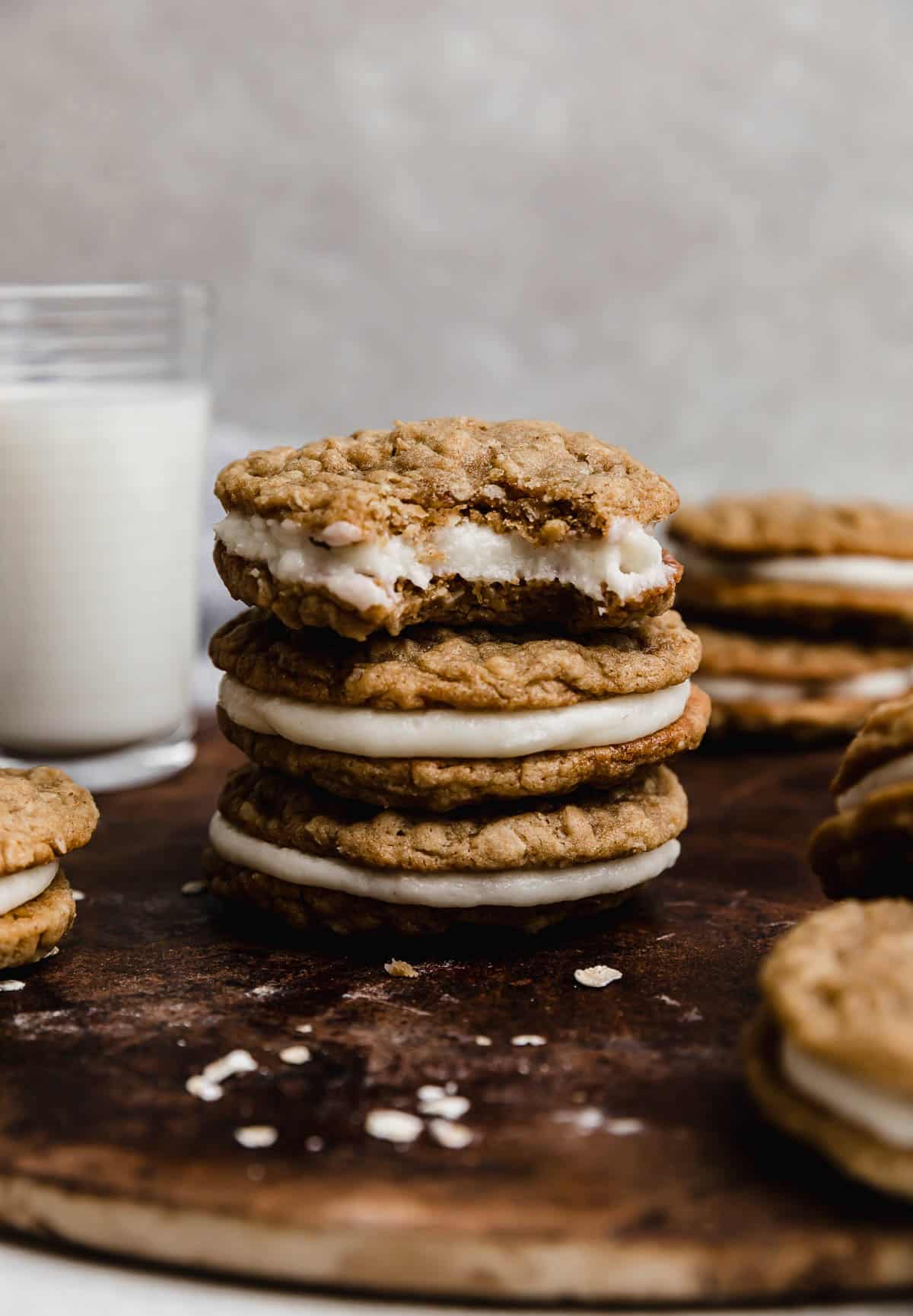 Three oatmeal creme pie cookies stacked, with the top cookie having a bite removed from it.