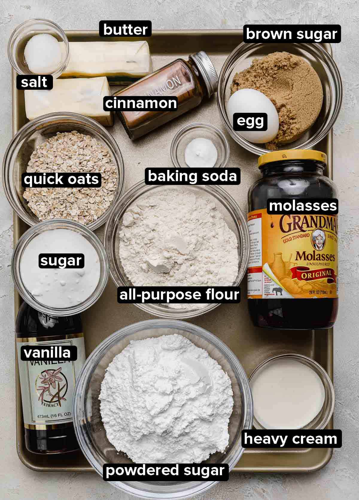Homemade Oatmeal Creme Pie ingredients portioned into glass bowls on a gold baking sheet.
