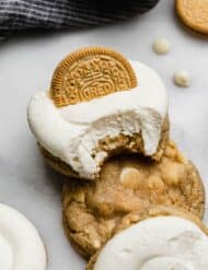Copycat Crumbl golden oreo cookie recipe topped with white frosting and half of a golden oreo.