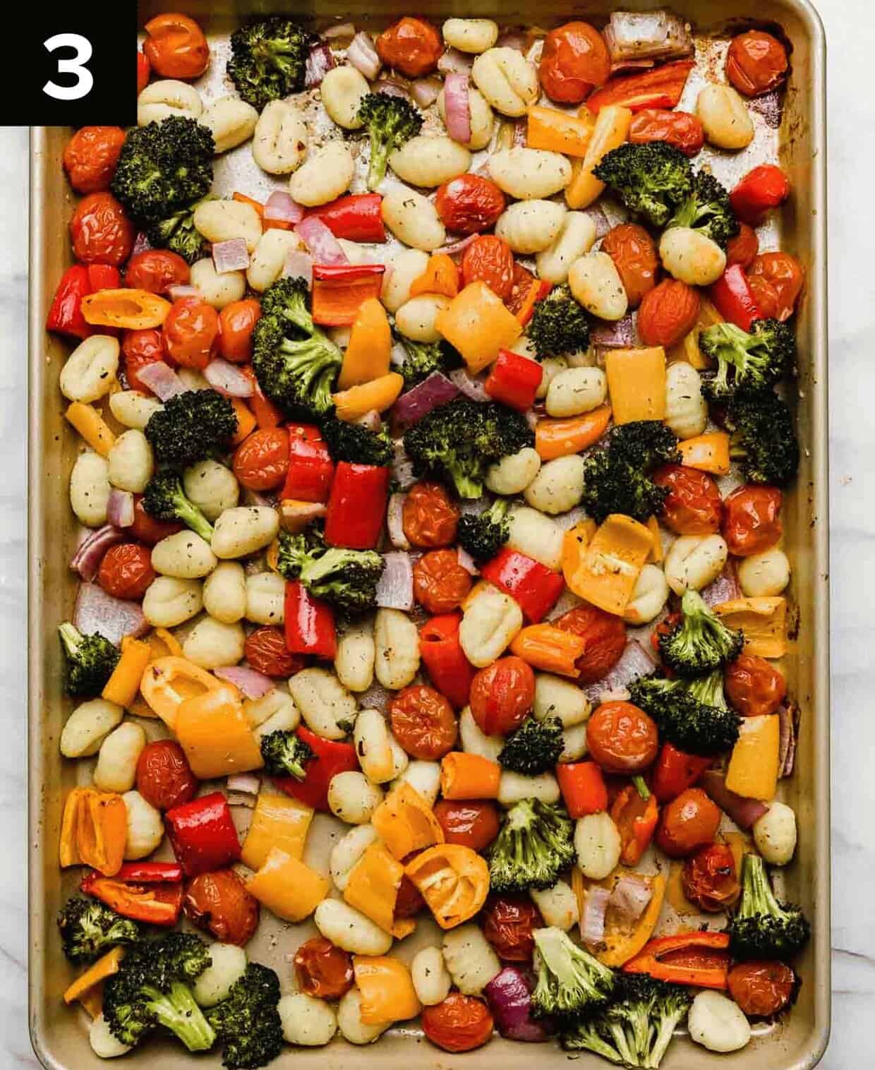 Roasted gnocchi and vegetables on a baking sheet.
