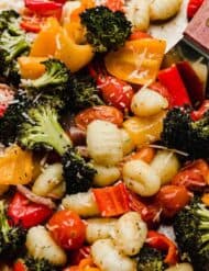 Easy roasted gnocchi and vegetables on a sheet pan: broccoli, peppers, red onion, and tomatoes.