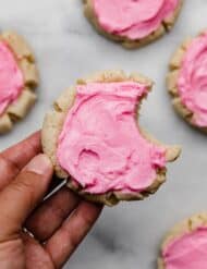 Copycat Swig sugar cookie topped with pink frosting, with a bite taken out of the cookie.