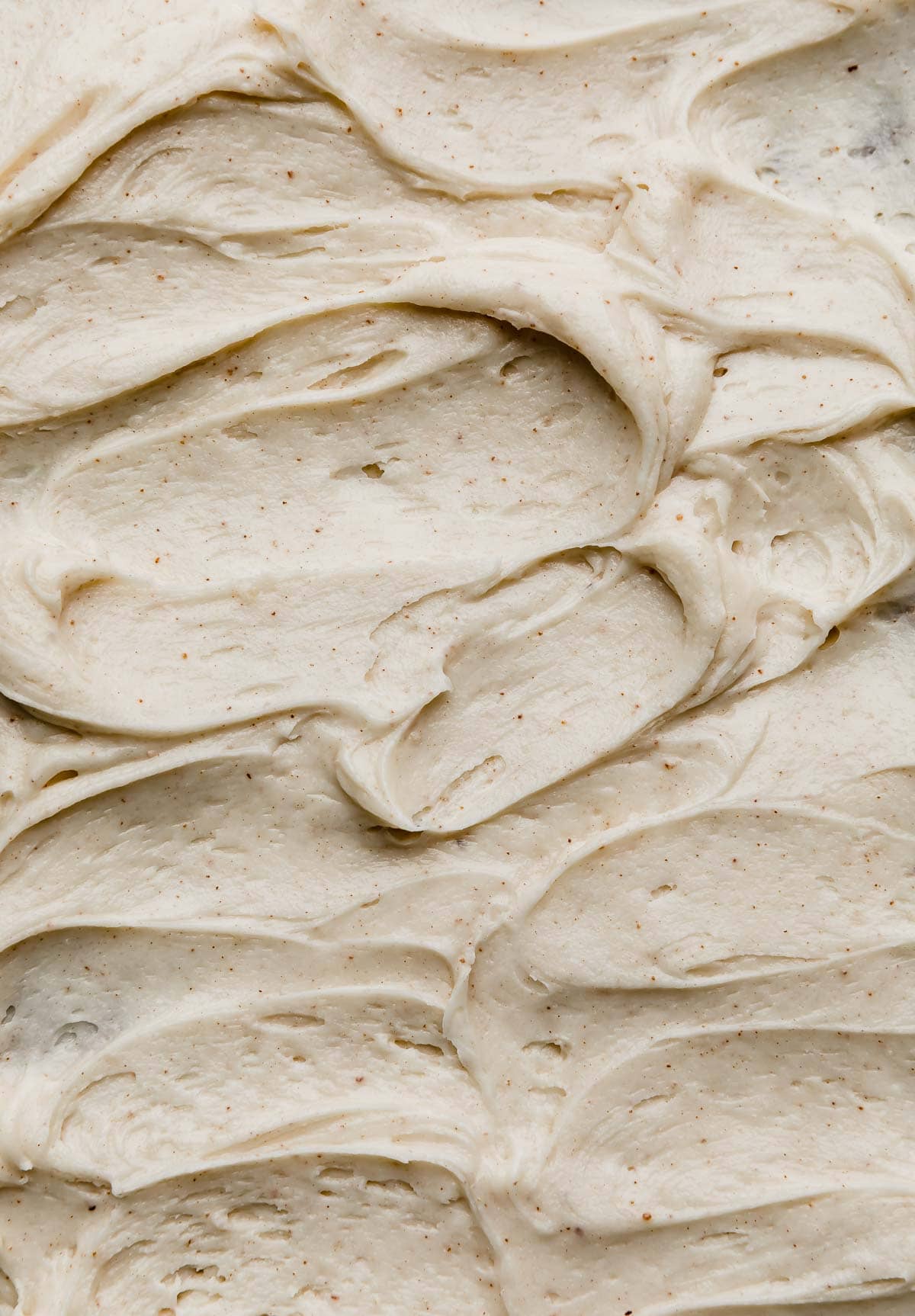 Swirled easy Brown Butter Cream Cheese Frosting recipe on a cake or other type of dessert.