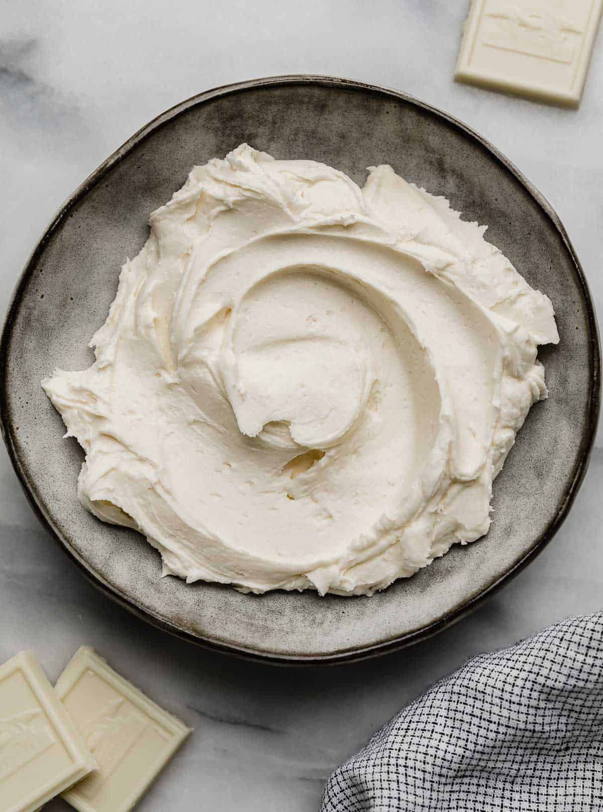 A gray bowl filled with homemade White Chocolate Buttercream Frosting.