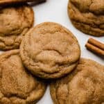 Easy chewy Brown Butter Pumpkin Snickerdoodle cookies on a white surface with a cinnamon stick in the background.