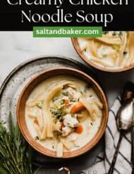A heartwarming homemade chicken noodle soup that is extra creamy, in a brown bowl that's on a gray plate. With the words, "Creamy Chicken Noodle Soup" written in white text above the photo.